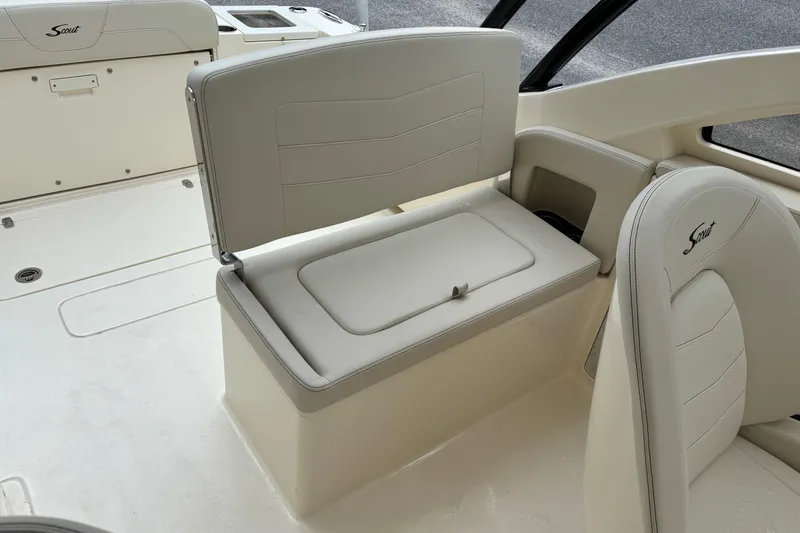 Slide: The Image of 2026 Scout 240 Dorado boat interior with beige seating and storage compartment. - 22