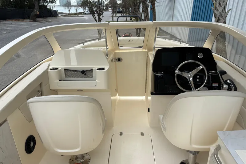 Slide: The Image of 2026 Scout 240 Dorado boat interior with steering wheel and seating. - 28