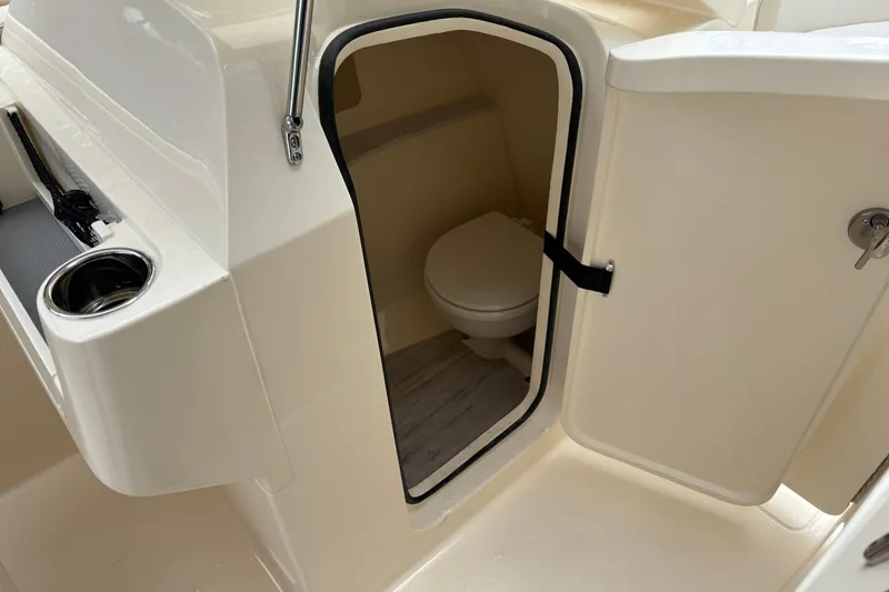 Slide: The Image of 2026 Scout 240 Dorado boat interior with open door revealing compact toilet. - 32