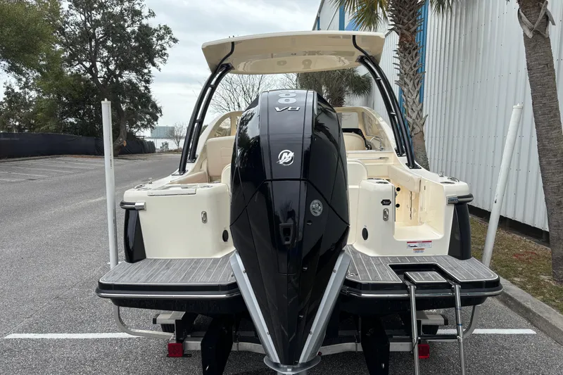 Slide: The Image of 2026 Scout 240 Dorado boat with powerful outboard motor, parked near palm trees. - 4