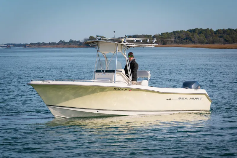 The Image of 2005 Sea Hunt Triton 232 boat on calm water with a person at the helm. - 0