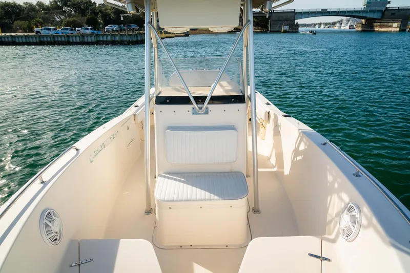 Slide: The Image of 2005 Sea Hunt Triton 232 boat interior with seating, on calm water near a bridge. - 10