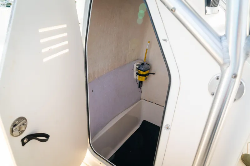 Slide: The Image of 2005 Sea Hunt Triton 232 boat interior with storage compartment and safety equipment. - 11