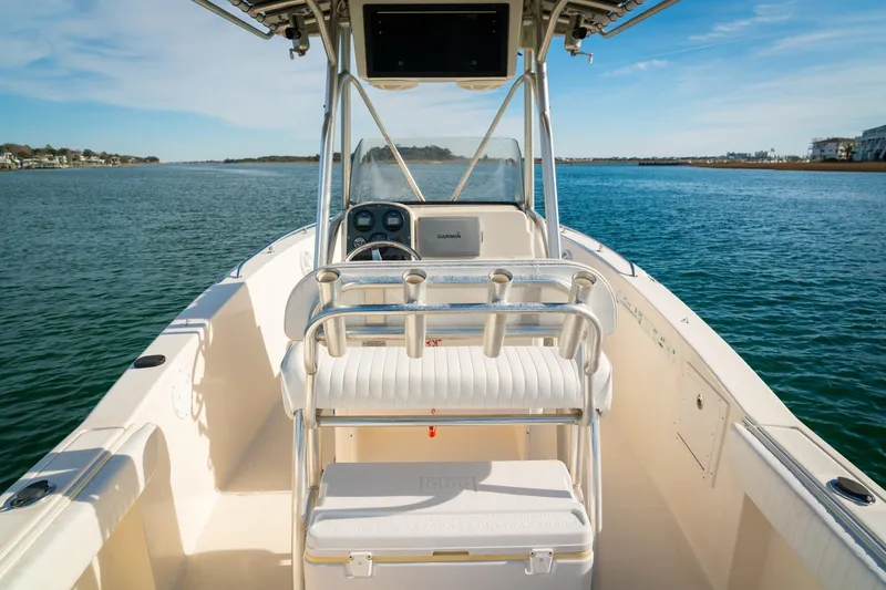 Slide: The Image of 2005 Sea Hunt Triton 232 boat on calm water, featuring a center console and seating. - 12