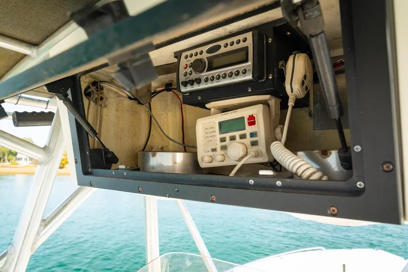 Slide: The Image of 2005 Sea Hunt Triton 232 boat electronics panel with radio and communication equipment. - 14