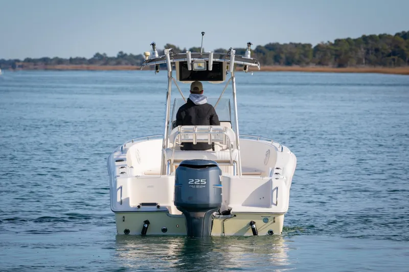 Slide: The Image of 2005 Sea Hunt Triton 232 boat on calm water, rear view with outboard motor. - 6