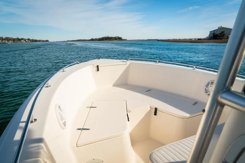 Slide: The Image of 2005 Sea Hunt Triton 232 boat on calm water, featuring spacious seating and clear skies. - 8