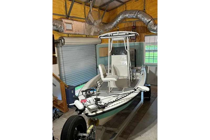Slide: The Image of 1998 Sea Strike 18 CC boat in garage, featuring a center console and trolling motor. - 1
