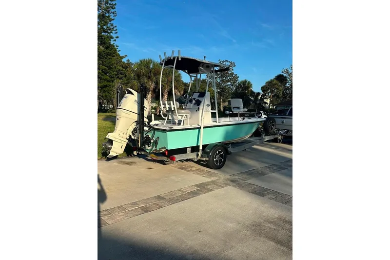 Slide: The Image of 1998 Sea Strike 18 CC boat on trailer, parked outdoors under clear blue sky. - 2