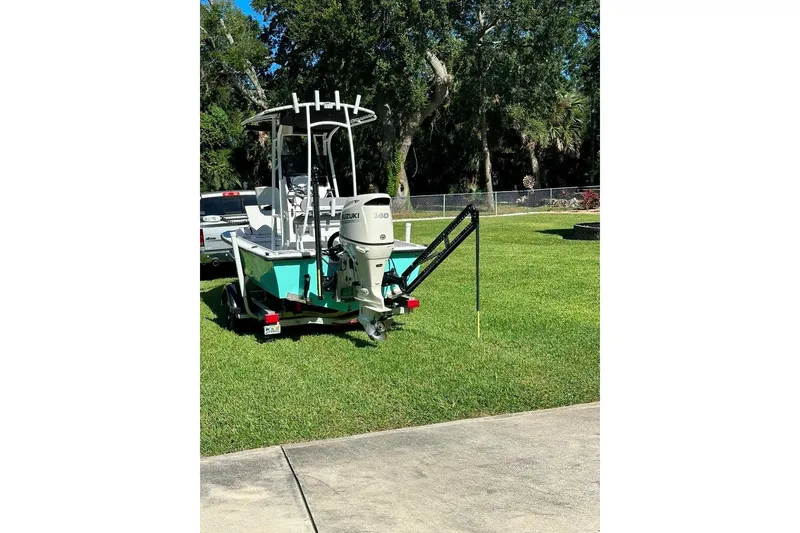 Slide: The Image of 1998 Sea Strike 18 CC boat with Suzuki motor on trailer, parked on grass. - 3