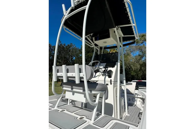 Slide: The Image of 1998 Sea Strike 18 CC boat interior with steering console and seating, under clear blue sky. - 4