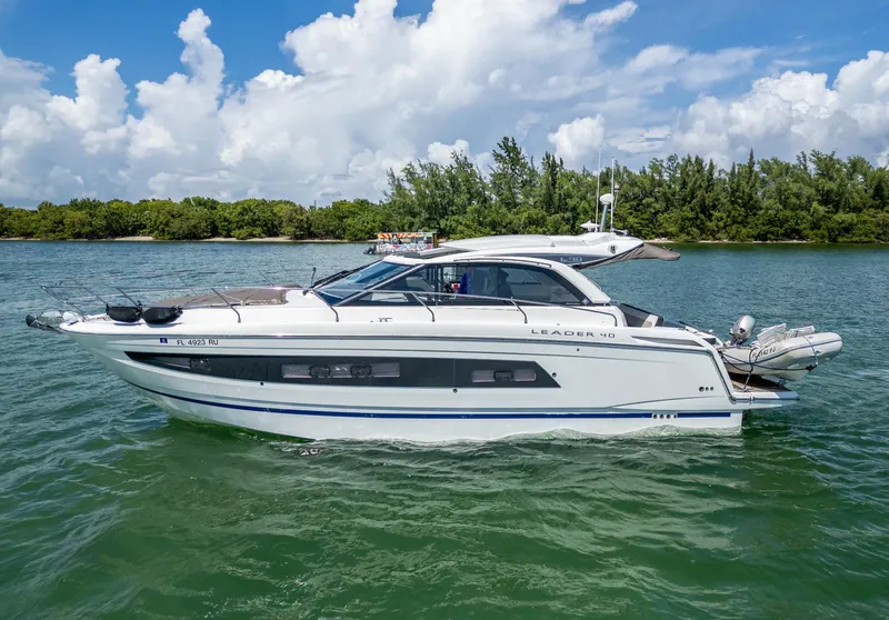 The Image of 2019 Jeanneau Leader 40 yacht cruising on a sunny day with lush greenery in the background. - 0