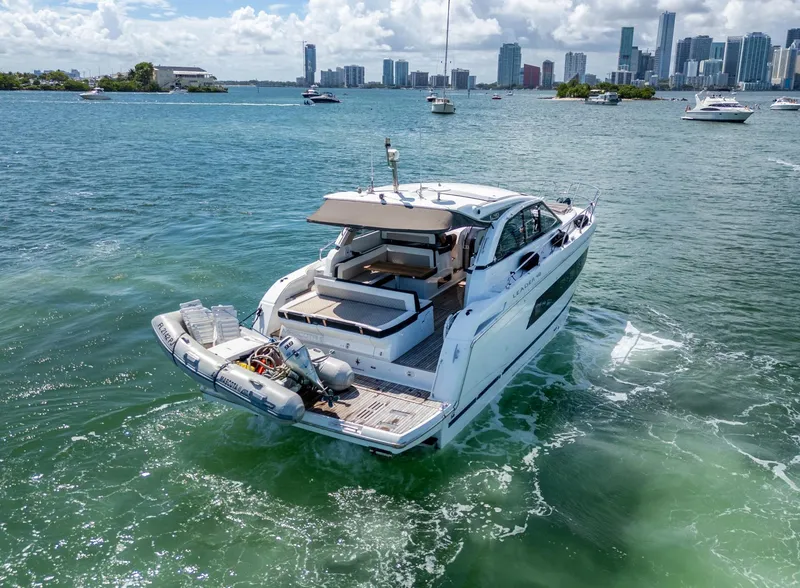 Slide: The Image of 2019 Jeanneau Leader 40 yacht cruising in sunny waters near a city skyline. - 16