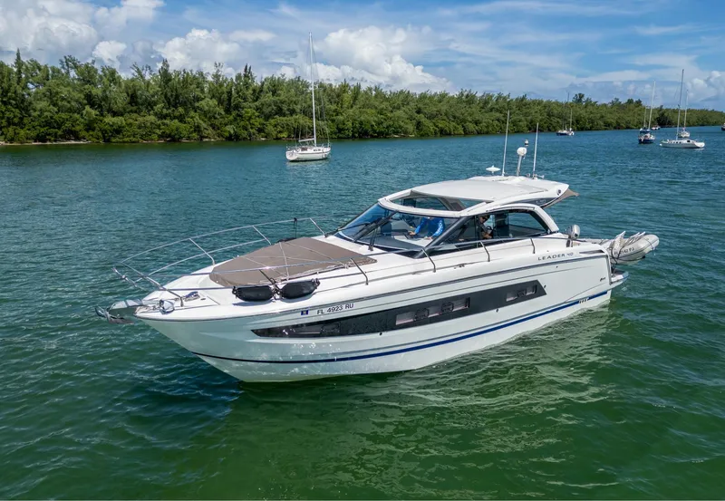 Slide: The Image of 2019 Jeanneau Leader 40 yacht cruising on a serene lake with lush greenery. - 21