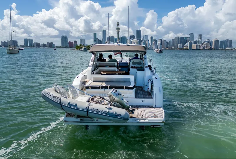 Slide: The Image of 2019 Jeanneau Leader 40 yacht cruising near city skyline, with inflatable boat attached. - 24