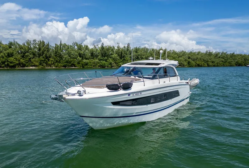 Slide: The Image of 2019 Jeanneau Leader 40 yacht cruising on a serene waterway under a clear blue sky. - 28