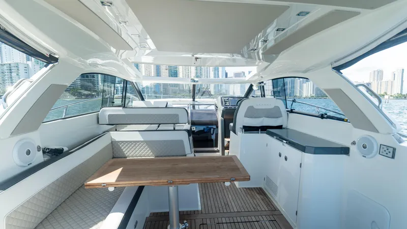 Slide: The Image of 2019 Jeanneau Leader 40 yacht interior with seating, table, and cityscape view. - 34