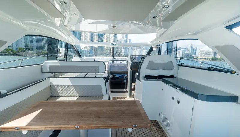Slide: The Image of 2019 Jeanneau Leader 40 yacht interior with modern seating and wooden table, cityscape view. - 35