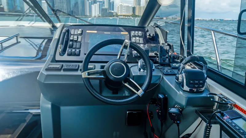 Slide: The Image of Helm of 2019 Jeanneau Leader 40 yacht with city skyline in background. - 40