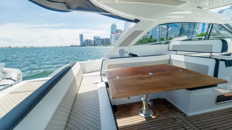 Slide: The Image of 2019 Jeanneau Leader 40 yacht interior with elegant seating and wooden table, overlooking city skyline. - 48