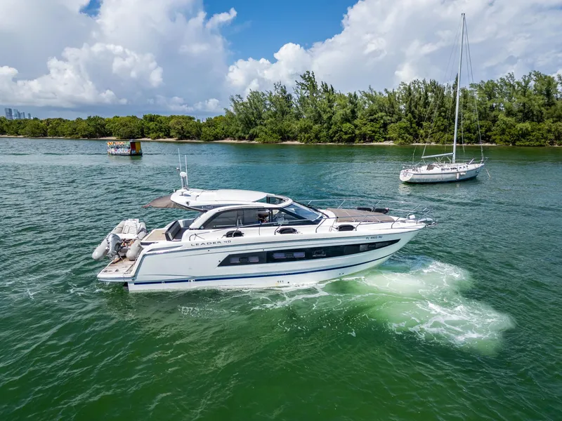 Slide: The Image of 2019 Jeanneau Leader 40 yacht cruising on a scenic, green waterway. - 5