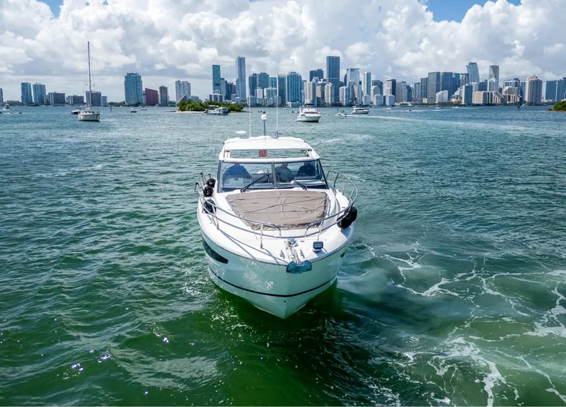 Slide: The Image of 2019 Jeanneau Leader 40 yacht cruising near a city skyline on a sunny day. - 9