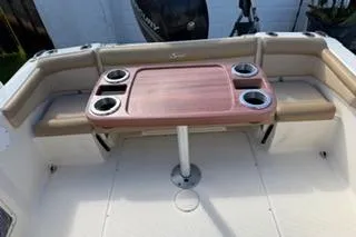 Slide: The Image of 2020 Scout 215 Dorado boat interior with seating and table, featuring cup holders. - 9