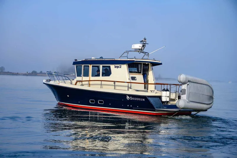 Slide: The Image of 2020 Targa 32 boat cruising on calm water under clear blue sky. - 1