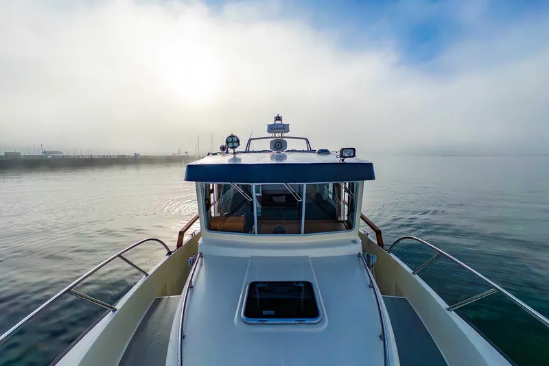 Slide: The Image of 2020 Targa 32 boat on calm water under a misty sky. - 10