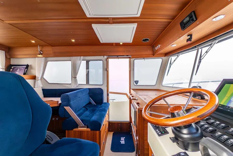 Slide: The Image of Interior of 2020 Targa 32 boat with wooden helm and blue seating. - 24