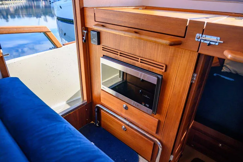 Slide: The Image of Interior of 2020 Targa 32 boat with wooden cabinetry and built-in microwave. - 28