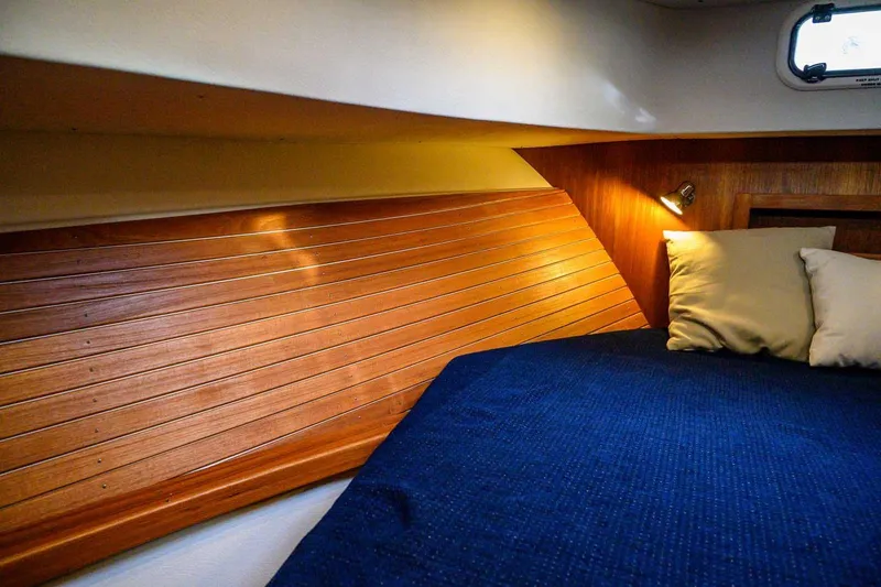 Slide: The Image of Cozy cabin interior of 2020 Targa 32 boat with wooden paneling and blue bedding. - 31