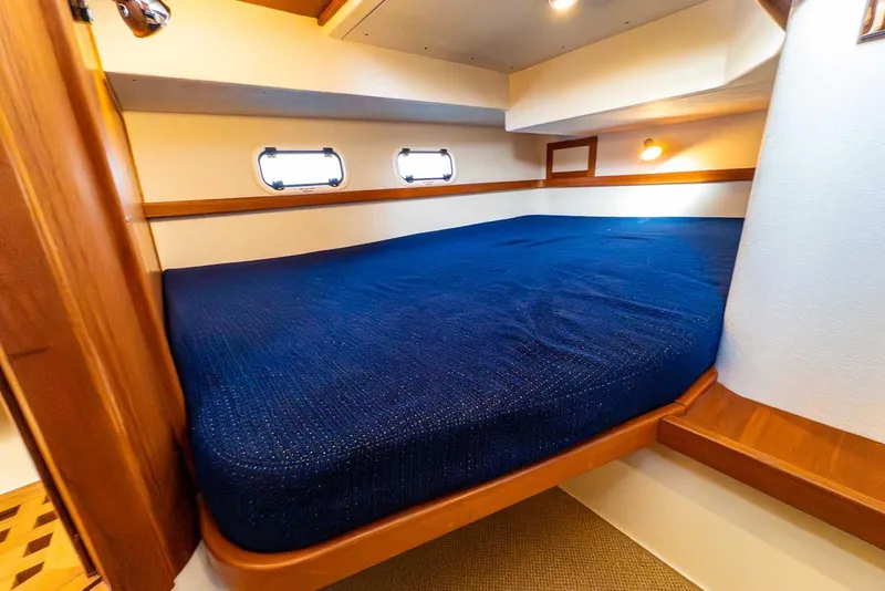 Slide: The Image of Cozy cabin interior of 2020 Targa 32 boat with blue bedding and wooden accents. - 33