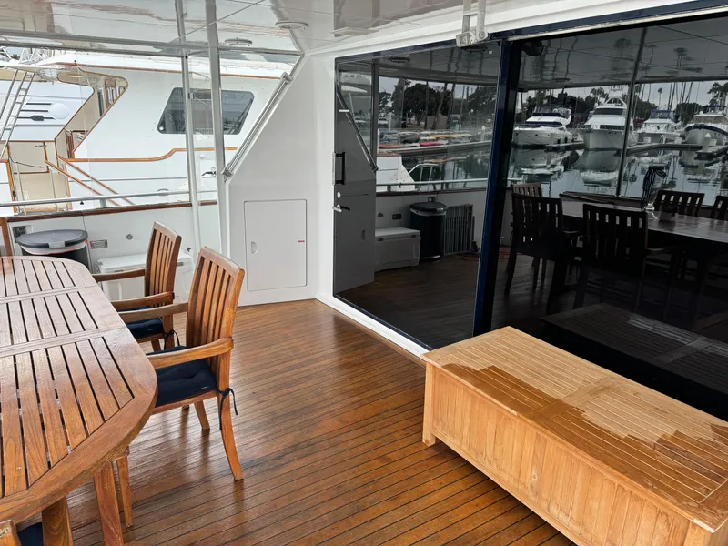 Slide: The Image of Outdoor deck of 1990 Versilcraft Challenger Motor Yacht with wooden furniture and marina view. - 10
