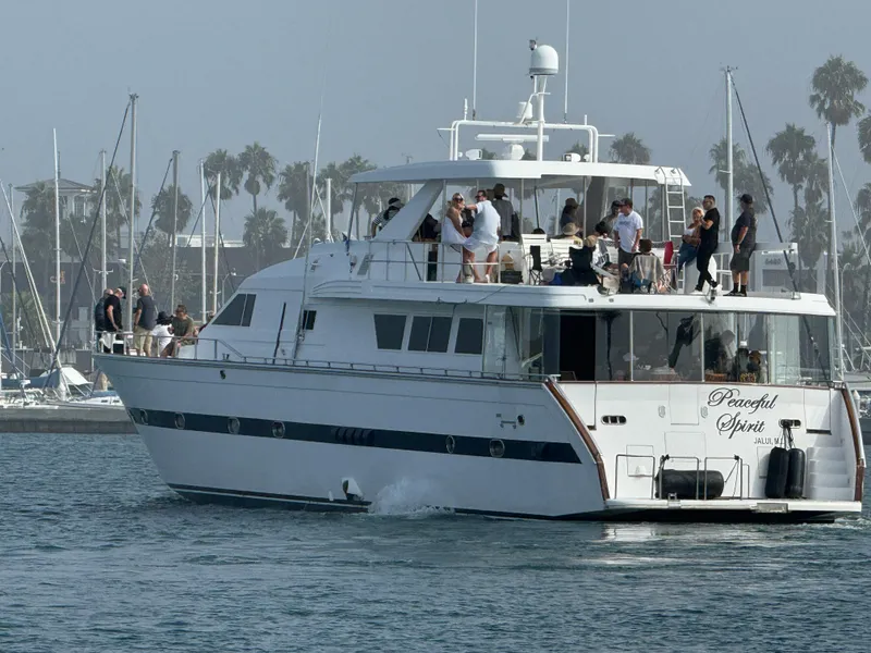 Slide: The Image of 1990 Versilcraft Challenger Motor Yacht cruising with passengers, docked in a marina. - 2