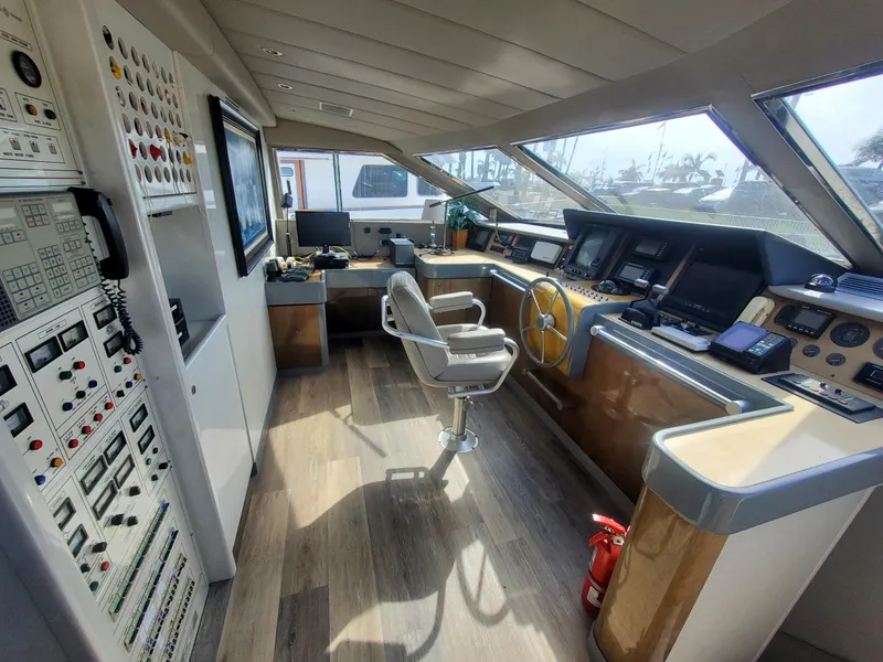 Slide: The Image of Versilcraft Challenger Motor Yacht 1990 helm with control panels and captain's chair, featuring panoramic windows. - 24