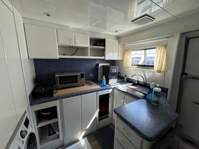 Slide: The Image of 1990 Versilcraft Challenger Motor Yacht kitchen with modern appliances and white cabinetry. - 31