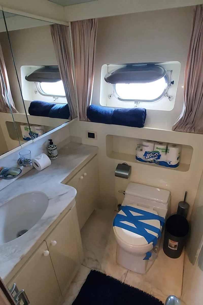 Slide: The Image of 1990 Versilcraft Challenger Motor Yacht bathroom with sink, toilet, and window. - 47