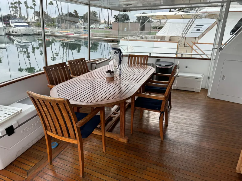 Slide: The Image of 1990 Versilcraft Challenger Motor Yacht deck with wooden dining table and chairs. - 8