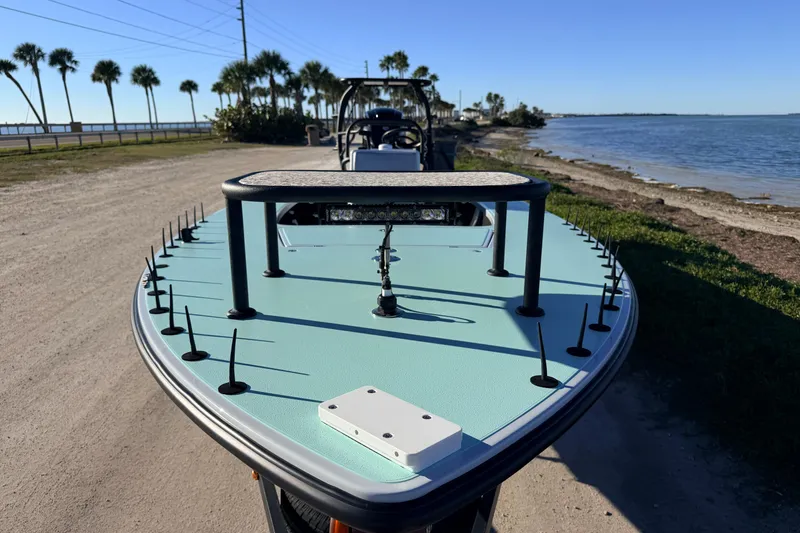 Slide: The Image of Chittum Skiffs Islamorada 18, 2021 model, parked by a scenic waterfront. - 23