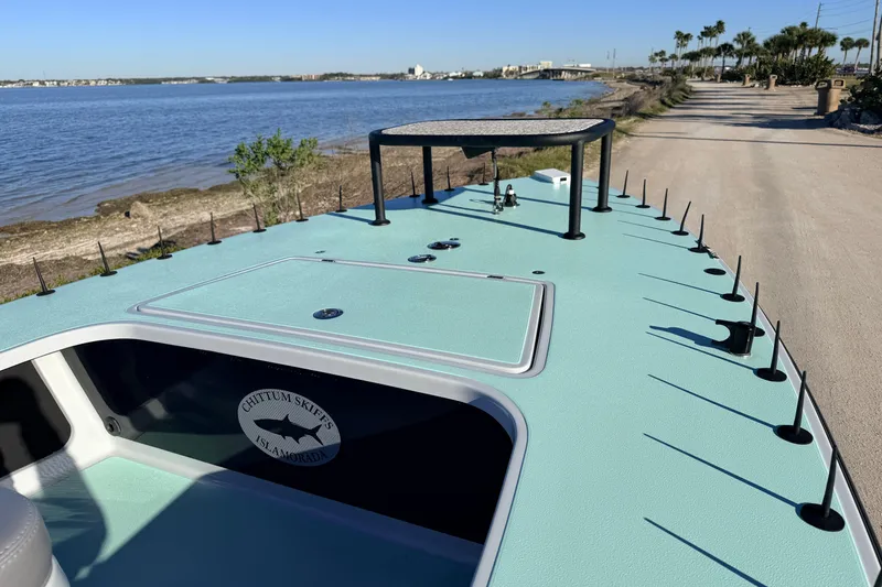 Slide: The Image of 2021 Chittum Skiffs Islamorada 18 on coastal road, showcasing sleek design and fishing features. - 24