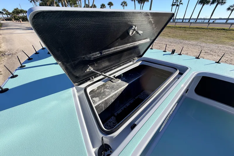 Slide: The Image of 2021 Chittum Skiffs Islamorada 18 with open storage compartment, coastal background. - 29