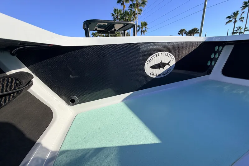 Slide: The Image of 2021 Chittum Skiffs Islamorada 18 interior with logo, palm trees in background. - 33