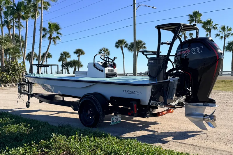 Slide: The Image of 2021 Chittum Skiffs Islamorada 18 boat with Mercury engine, parked near palm trees. - 4