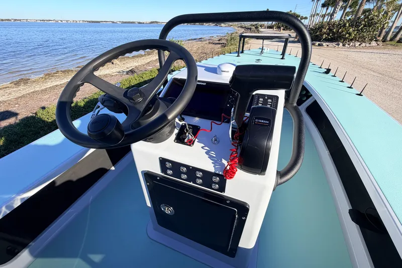 Slide: The Image of 2021 Chittum Skiffs Islamorada 18 boat console with steering wheel and controls by the water. - 44