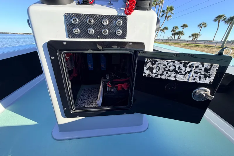 Slide: The Image of Open storage compartment on 2021 Chittum Skiffs Islamorada 18 boat, with control panel and scenic background. - 50