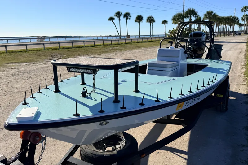 Slide: The Image of 2021 Chittum Skiffs Islamorada 18 boat on trailer, near waterfront with palm trees. - 7