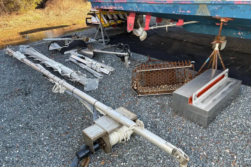 Slide: The Image of Custom 1994 workboat equipment and parts on gravel, including metal structures and winch. - 21