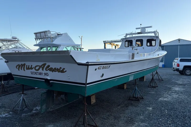 Slide: The Image of Custom 1994 workboat "Miss Alexis" on stands, white hull, green bottom, docked in a boatyard. - 4