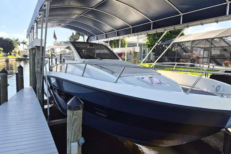Slide: The Image of 2013 Azimut 36 yacht docked under a canopy in a scenic marina. - 2